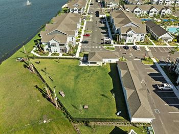 A bird's eye view of a residential area with houses, a road, and a body of water.